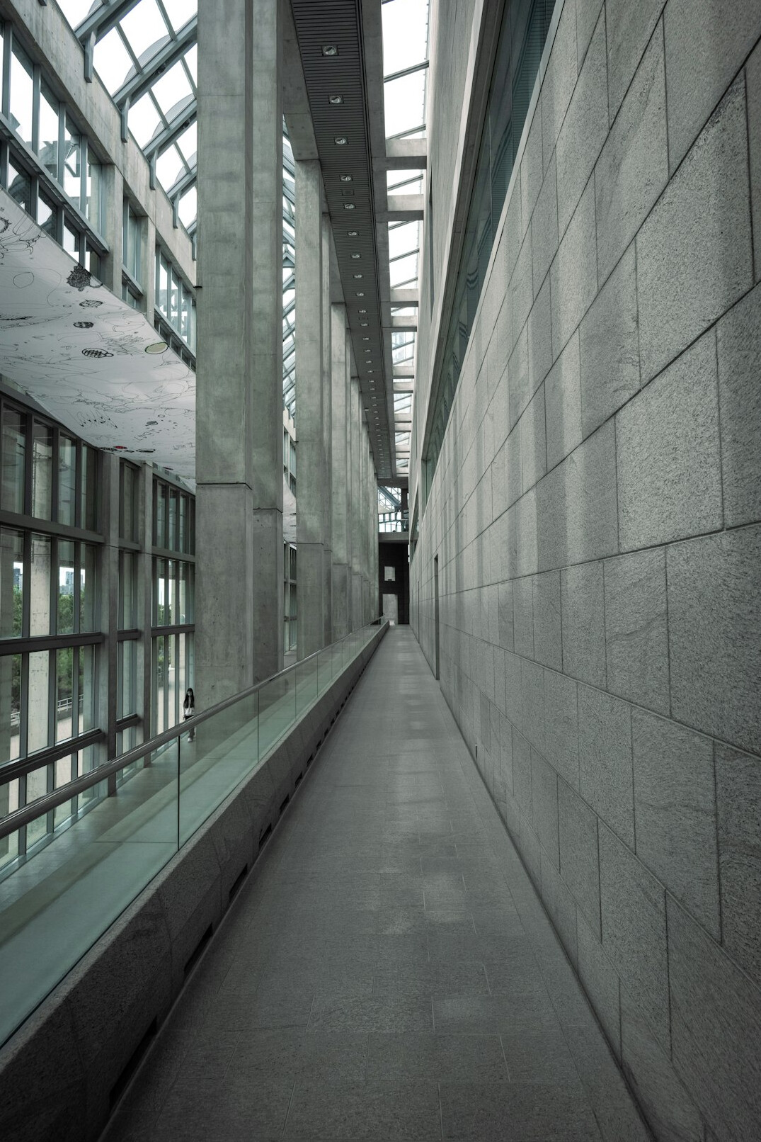 Distant silhouette of a person walking through an empty museum corridor